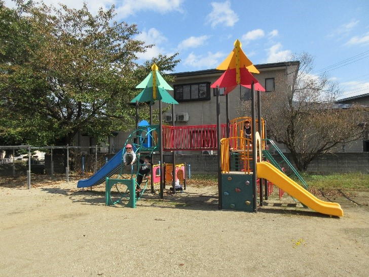 滑り台が二つ繋がった遊具で遊ぶ子どもの写真